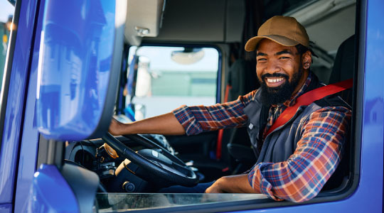 Photograph of a truck driver within a cab
