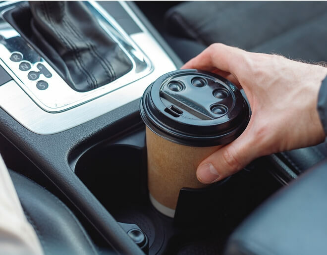 disposable coffee cup in car console