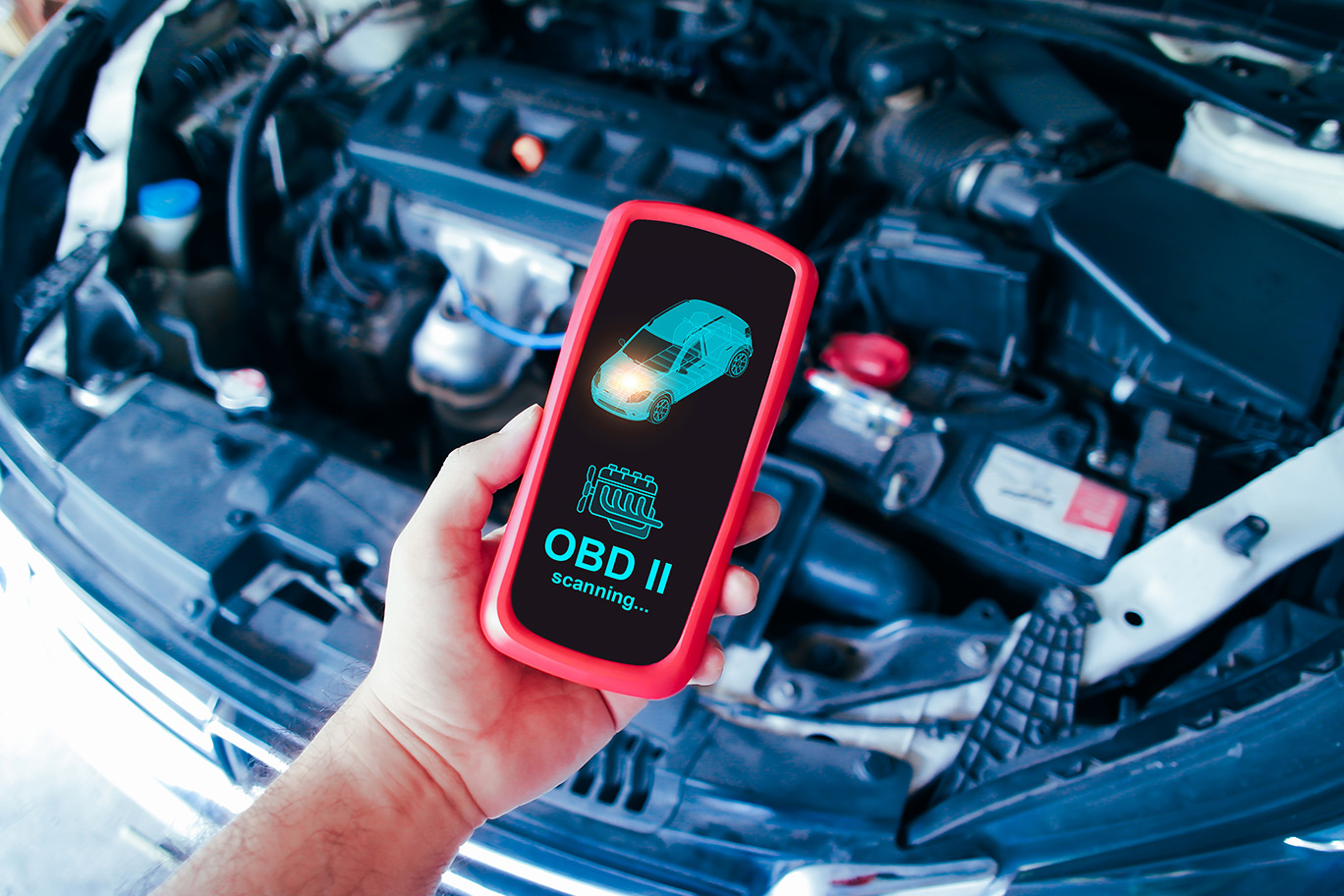 A person works on a car's open fuse box located in the engine bay while holding a small black component.