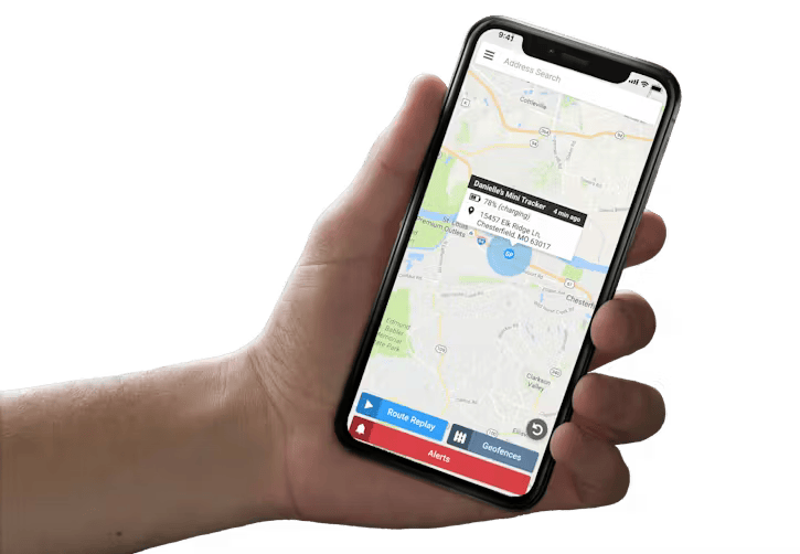 A hand holds a smartphone displaying a map application with an active location pin and navigation interface.