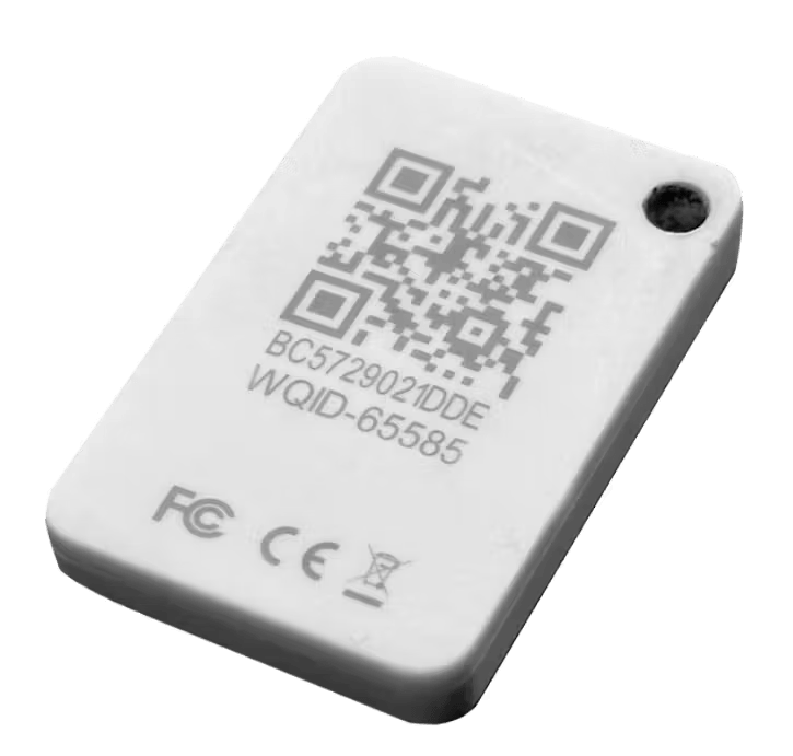 A small white rectangular electronic tag featuring a QR code, an alphanumeric identifier, and FCC and CE certification markings.
