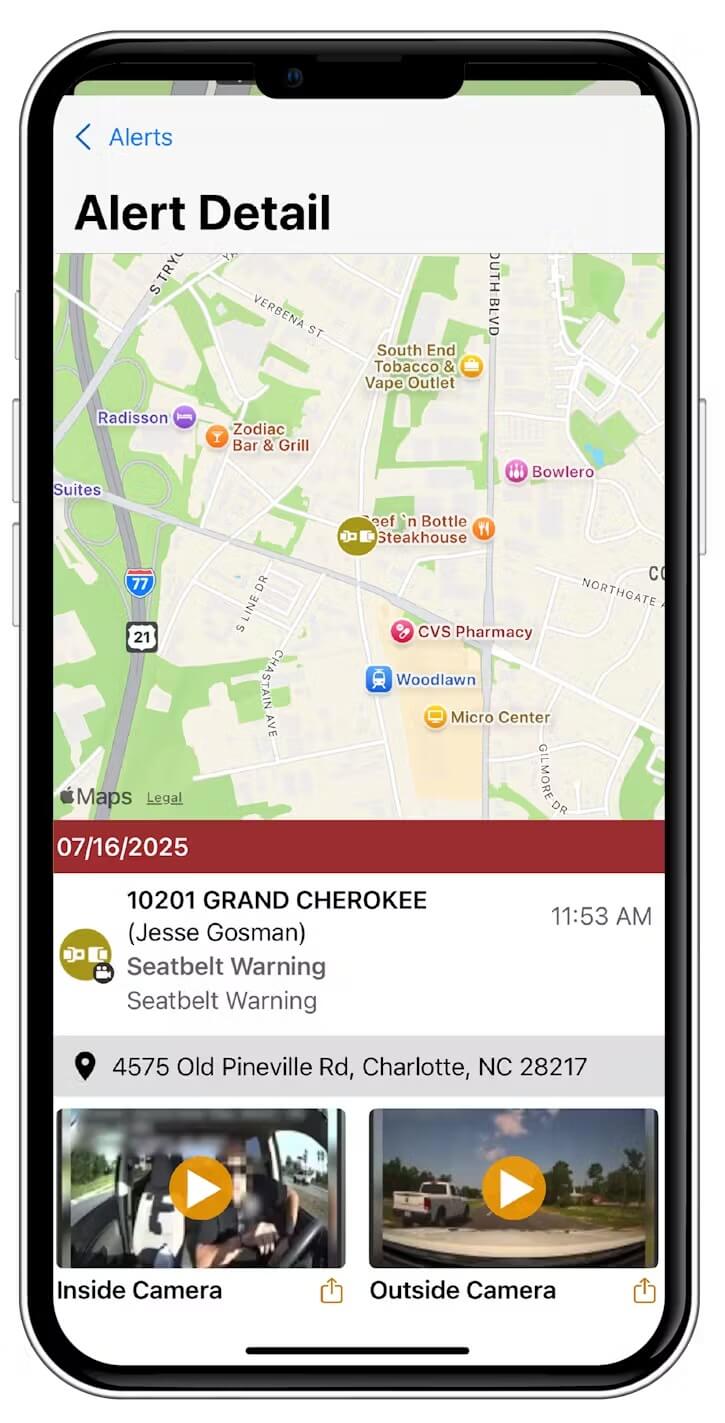 A smartphone screen displaying a vehicle alert for a seatbelt warning, including a map showing the vehicle's location and two video thumbnails from internal and external dash cameras.